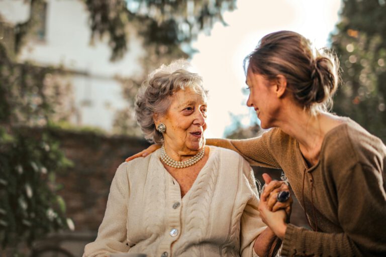 seniorin und erwachsene tochter glücklich im garten